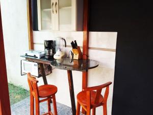 布卢梅瑙Espaço aconchegante Blumenau的桌子旁带两把椅子的柜台