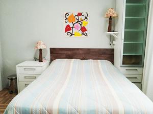 布卢梅瑙Espaço aconchegante Blumenau的一间卧室配有一张床、两个床头柜和两盏灯。