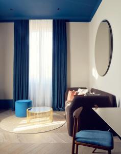 罗马Palazzo Velabro, a Member of Design Hotels的带沙发、桌子和镜子的客厅