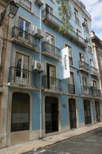 里斯本Hotel Portuense Lisboa的蓝色的建筑,旁边标有标志