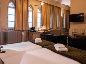 根特Hotel Monasterium PoortAckere Ghent的酒店客房配有两张床和一张书桌