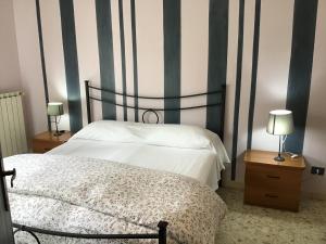 蒂沃利casa Marilena的一间卧室配有一张床和两张带台灯的桌子。