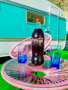 Los TablonesTropical Dreams Motril的粉色盘子上一瓶可可乐,两杯