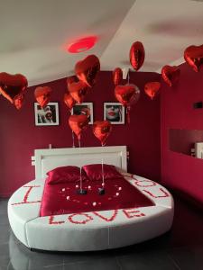LignéLoft d'amour的墙上有红色心床的房间