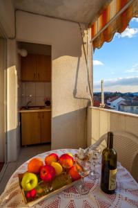 蒂瓦特Apartments Marko的一张桌子,上面放着一盘水果和一瓶葡萄酒