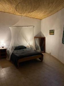Ngalou SessèneCase beach的一间卧室配有一张带蚊帐的床