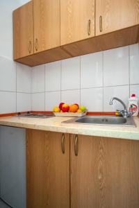 蒂瓦特Apartments Marko的厨房配有水槽,柜台上放着一碗水果