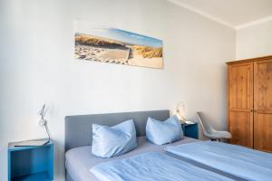 奥斯赛拜-塞林Haus Ferienglück Sauna im Haus的一间卧室配有一张带蓝色枕头的床和橱柜。