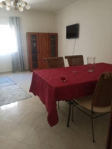 埃斯托伊Maravilhoso apartamento T2 Estoi的餐桌、红色桌布和椅子