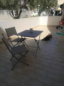 埃斯托伊Maravilhoso apartamento T2 Estoi的一只黑猫躺在桌子和椅子旁边