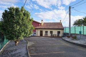 希洪Casa de pueblo adosada, en la zona rural de Gijón.的前面有停车位的房子