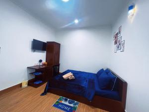 芹苴Nhan Tay Hostel的客厅配有蓝色的床和橱柜。