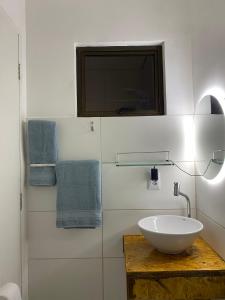 费尔南多 - 迪诺罗尼亚La em casa Noronha的一间带水槽、电视和毛巾的浴室