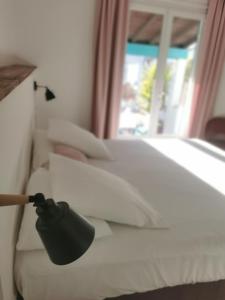 圣马迪拉莫卡马尔古埃瑟酒店的白色床上的黑灯,带窗户