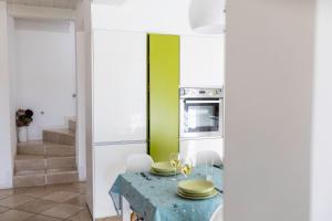 莫尔费塔B&B Samarelle - Exclusive Villa的厨房配有桌子和绿色的墙壁