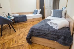 大特尔诺沃Apartment Zdravets的一间卧室设有两张床,铺有木地板