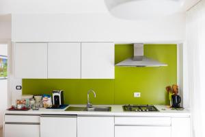 莫尔费塔B&B Samarelle - Exclusive Villa的厨房配有白色橱柜和绿色墙壁
