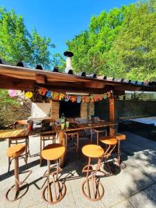 ZlobinKuća za odmor Tomić的庭院设有带凳子和烧烤架的酒吧
