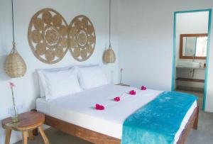 佩德拉斯港CHALÉ NAMORADA PATACHO的卧室配有白色的床铺,上面有红色的鲜花