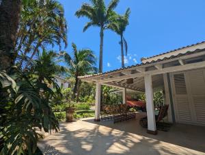 圣塞巴斯蒂安Linda Casa Praia de Pauba em condominio的一个带凉棚和棕榈树的庭院