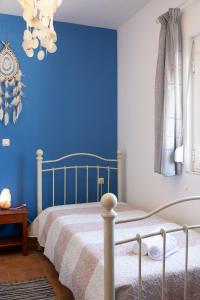 SkouloúfiaRural Residence的一间卧室配有一张蓝色墙壁的床