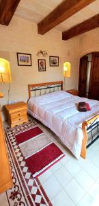 圣劳伦斯Ta Majsi farmhouse with indoor heated pool的一间卧室配有一张大床和一张桌子