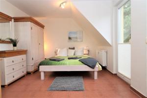 Neuhaus"Strandkoje" Strandkoje, App 07的一间卧室配有一张带绿毯的床