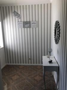 维拉·诺瓦·达·塞尔维尔Apartamento Rio Minho的一间设有桌子和条纹墙的房间