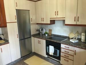 维拉·诺瓦·达·塞尔维尔Apartamento Rio Minho的厨房配有木制橱柜和黑色冰箱。