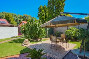 逊邱伦The Lemon Tree Oasis - Solar的一个带桌子和遮阳伞的庭院