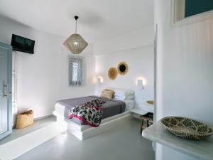 纳乌萨Ariti Seaside Residence的一间白色客房内的床铺卧室