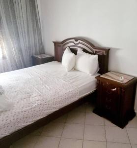 Sidi Bou JoblineLa villa de la mer的一间卧室配有一张带木制床头板和床头柜的床。