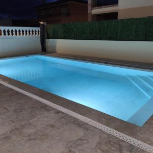 BáscaraCasa Empordà con piscina exclusiva的地板上设有蓝色灯光的大型游泳池
