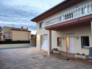 BáscaraCasa Empordà con piscina exclusiva的带阳台和车道的白色房屋