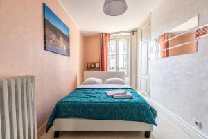 克莱蒙费朗Hyper centre Clermont-Ferrand F2 Etat Unis的小卧室配有一张带蓝色毯子的床