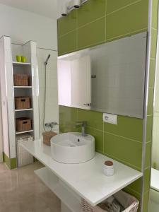 韦尔瓦Hoyo 20 de La Monacilla Golf的一间带水槽和镜子的浴室