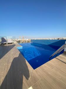 达喀尔Magnifique Appartement avec PISCINE, 3 Chambres, 4 Salles de Bain, Salle de Gym et Terrasse, LUXE ET COMFORT aux ALMADIES的建筑物屋顶上的蓝色游泳池