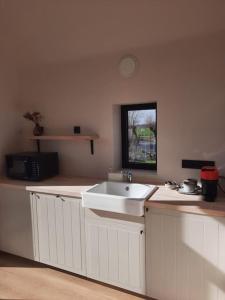KruisemKomo Hill Stays - guestroom Komo Cosy的厨房配有水槽和台面