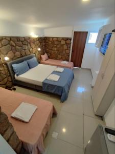 埃拉特Guest House "Villa Klara Eilat" Heated pool and sauna all year round的一间卧室设有两张床和石墙