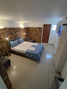 埃拉特Guest House "Villa Klara Eilat" Heated pool and sauna all year round的一间卧室设有一张床和石墙