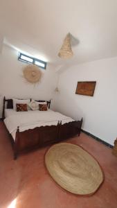马拉喀什Dar Malwan的卧室配有一张大床,地板上铺有大地毯
