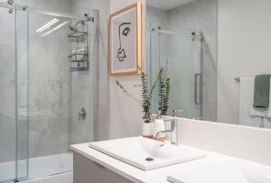 雷夫尔斯托克Adanac by Revelstoke Vacations的白色的浴室设有水槽和淋浴。