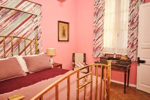 乌拉圭河畔康塞普西翁Palacio Santa Candida的卧室设有粉红色的墙壁、一张床和一张书桌