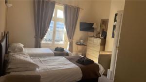滨海韦斯顿皇家格罗夫纳酒店的酒店客房设有两张床和窗户。