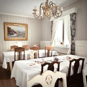 EidsvollVILLA HASSELBAKKEN的一间带2张桌子和吊灯的用餐室