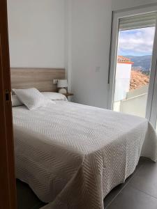 科尔库维翁Apartamentos Corcubión的卧室设有白色的床和大窗户