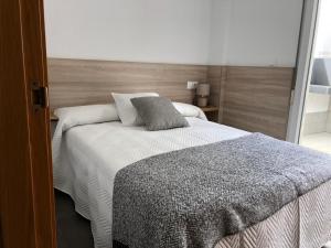科尔库维翁Apartamentos Corcubión的一间卧室配有一张带木制床头板的床