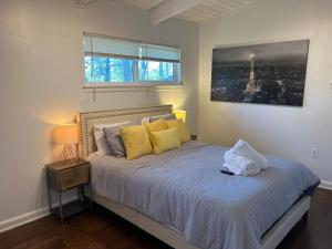 亚特兰大Recently renovated Haven in Brookhaven.的一间卧室配有一张带黄色枕头的床和一扇窗户