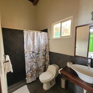 拉利伯塔德Kayu Surf Resort的一间带卫生间和水槽的浴室