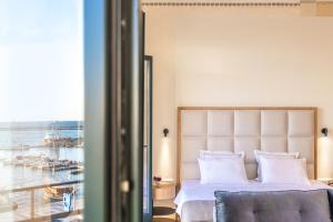 卡瓦拉EPICURE SUITES的一间卧室配有一张床,享有海港的景色